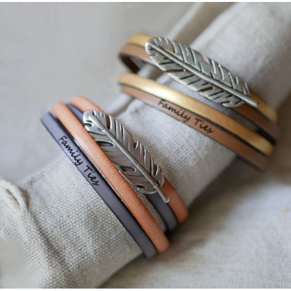 Doble correa de piel en d&uacute;o decorada con una pluma plateada