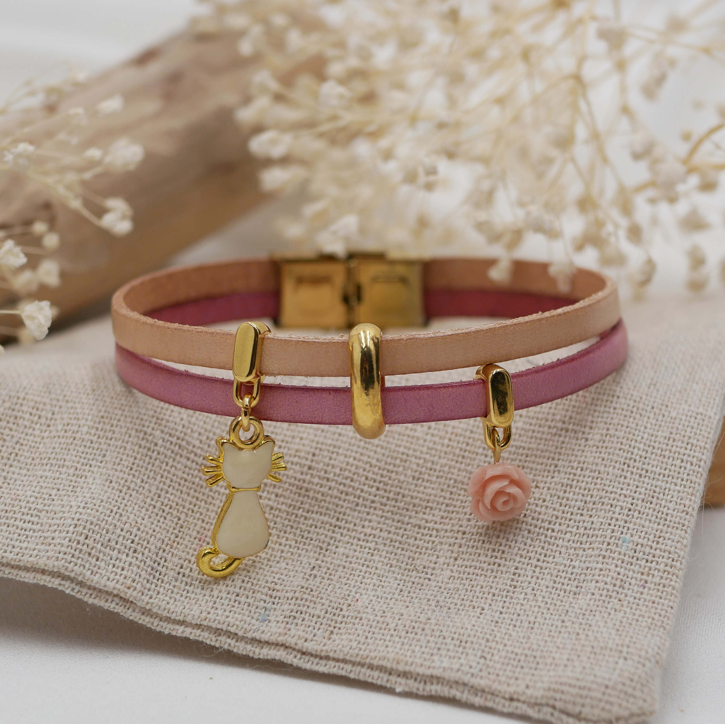 Pulsera dúo de cuero con gato dorado y colgantes rosas 