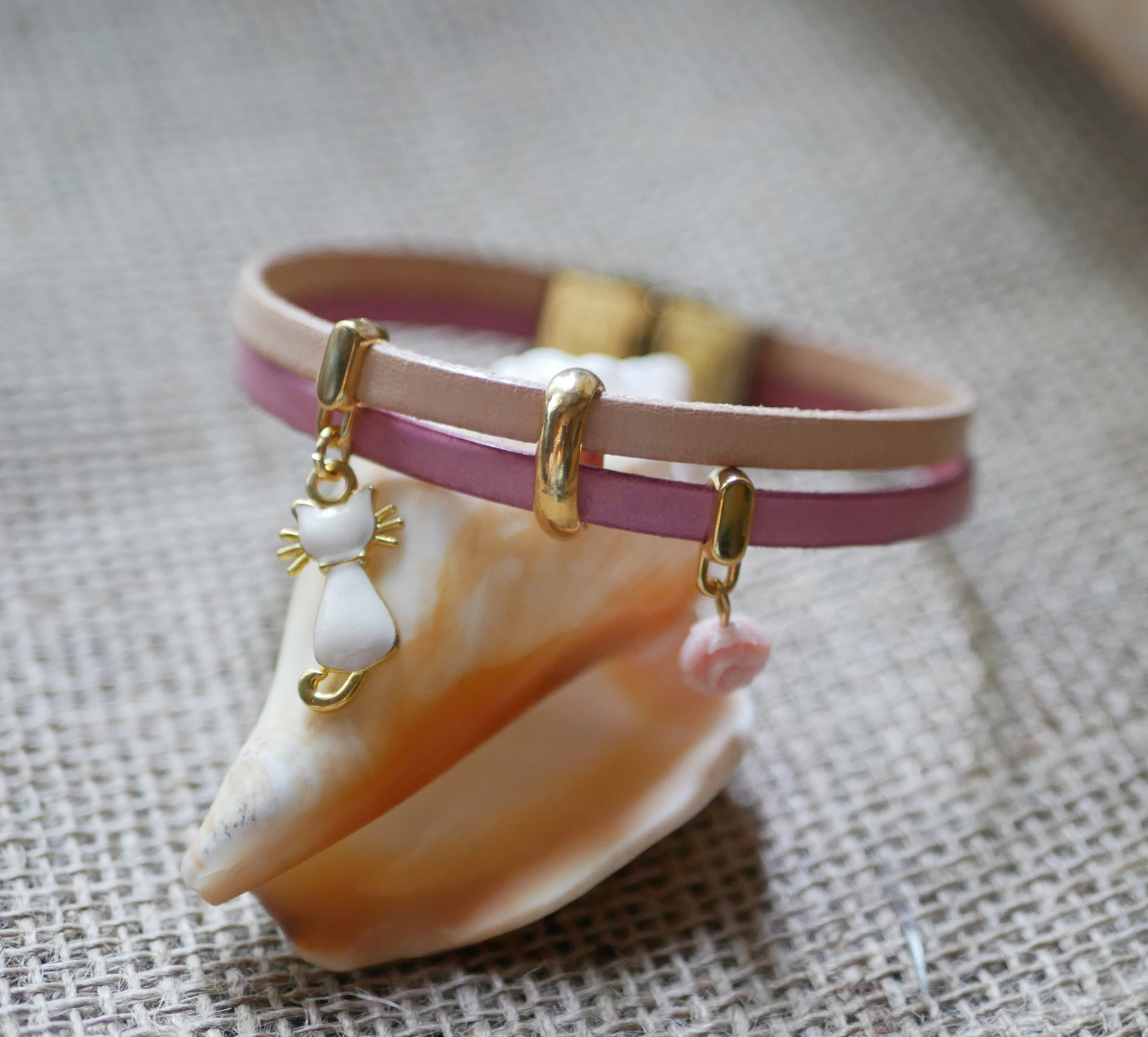 Pulsera dúo de cuero con gato dorado y colgantes rosas 