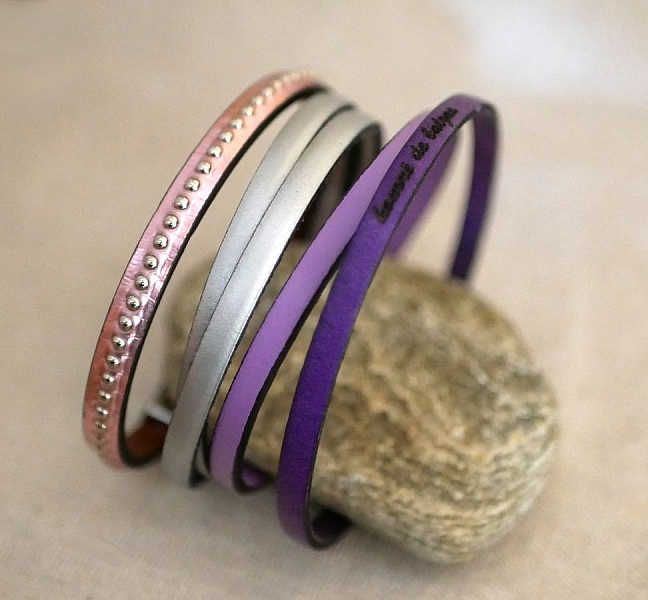 Bracelets femme en cuir coloré sur un galet.