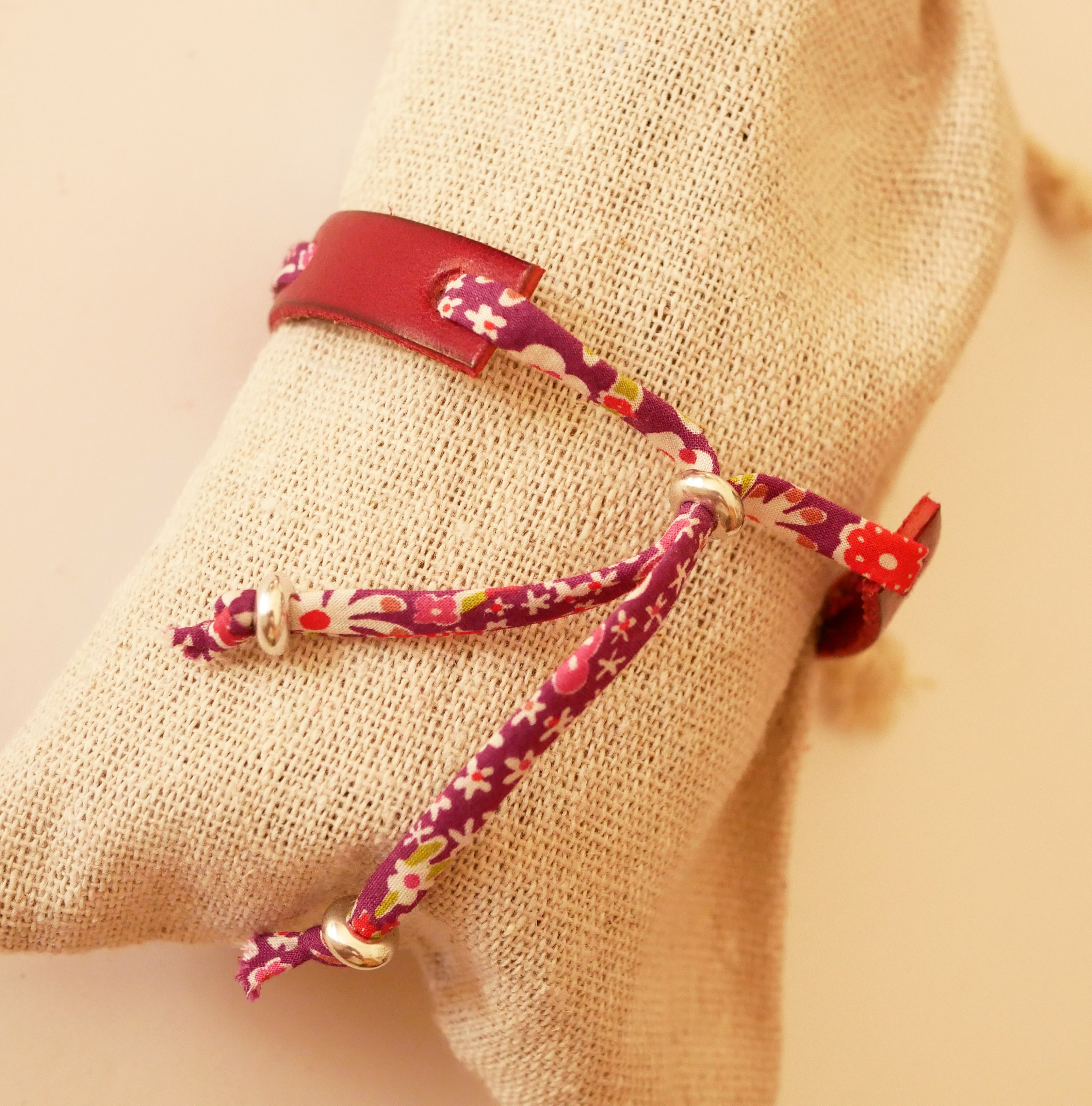 Florâme Pulsera Good vibes grabada con lazo liberty morado sobre piel roja
