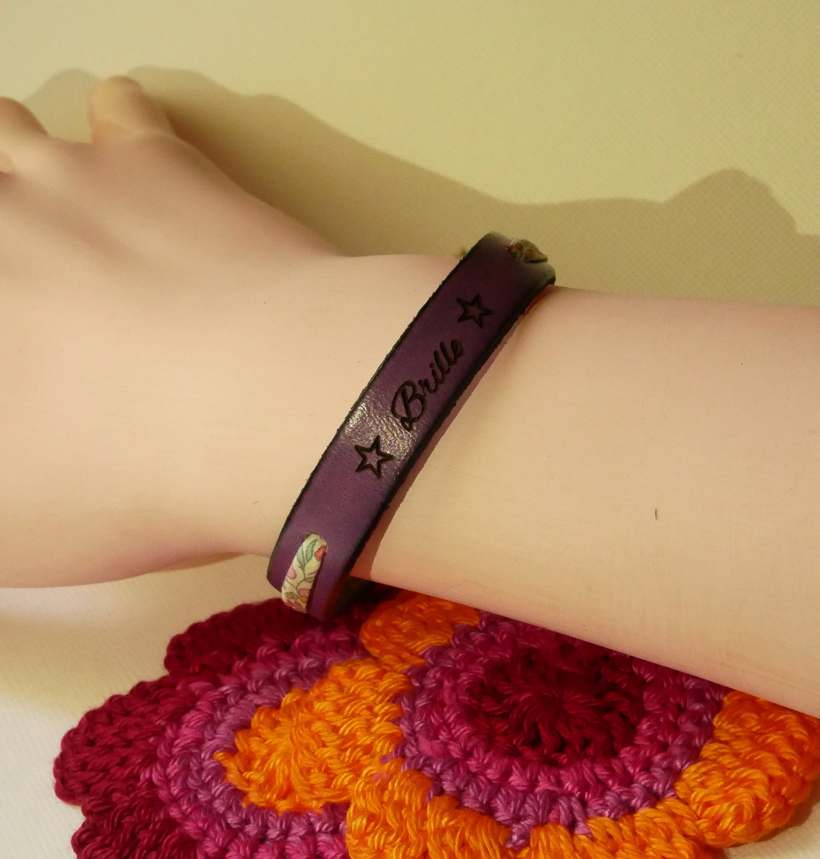 Pulsera Florâme "Brille" grabada con lazo liberty pastel sobre cuero morado