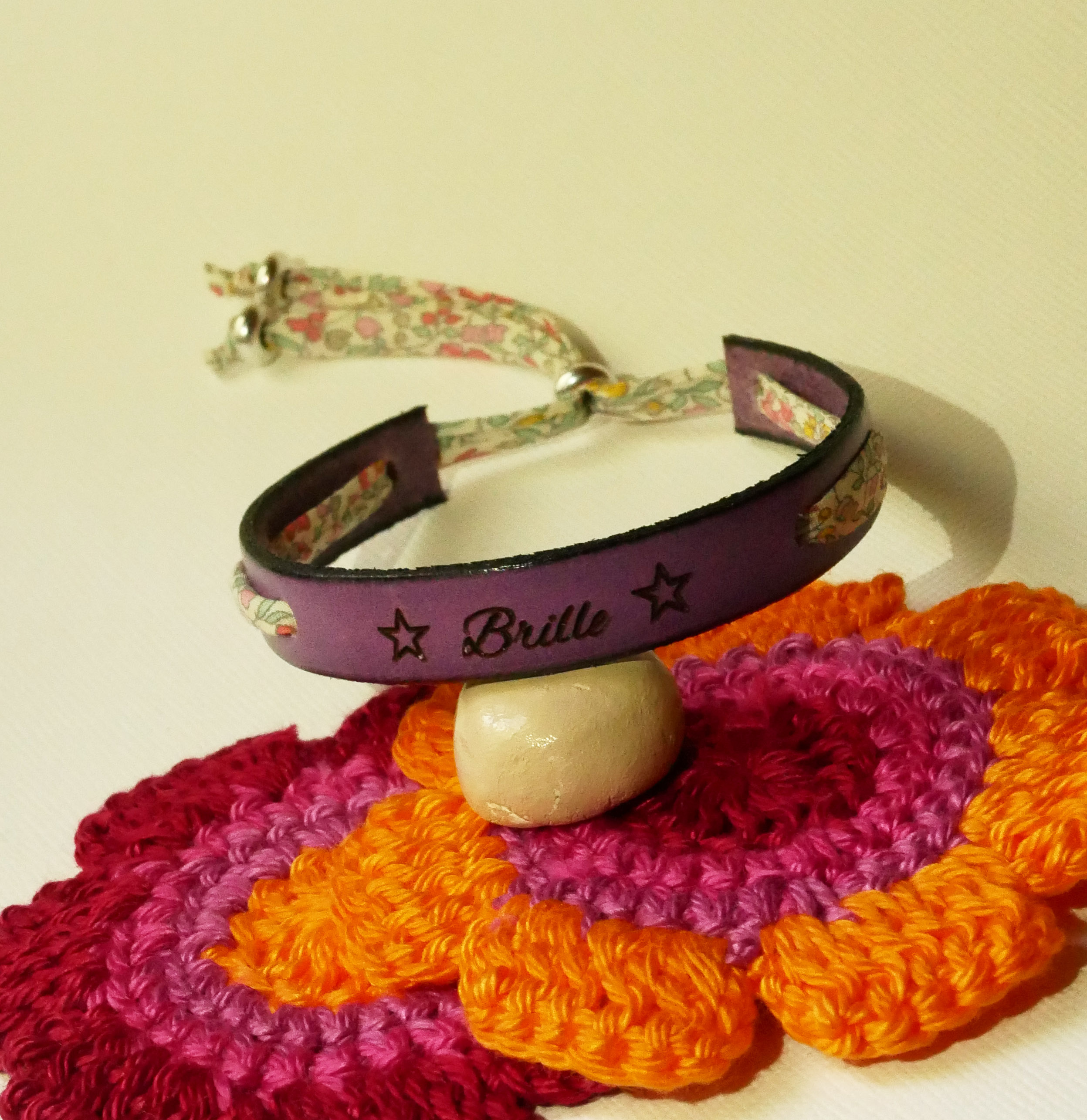 Pulsera Florâme "Brille" grabada con lazo liberty pastel sobre cuero morado