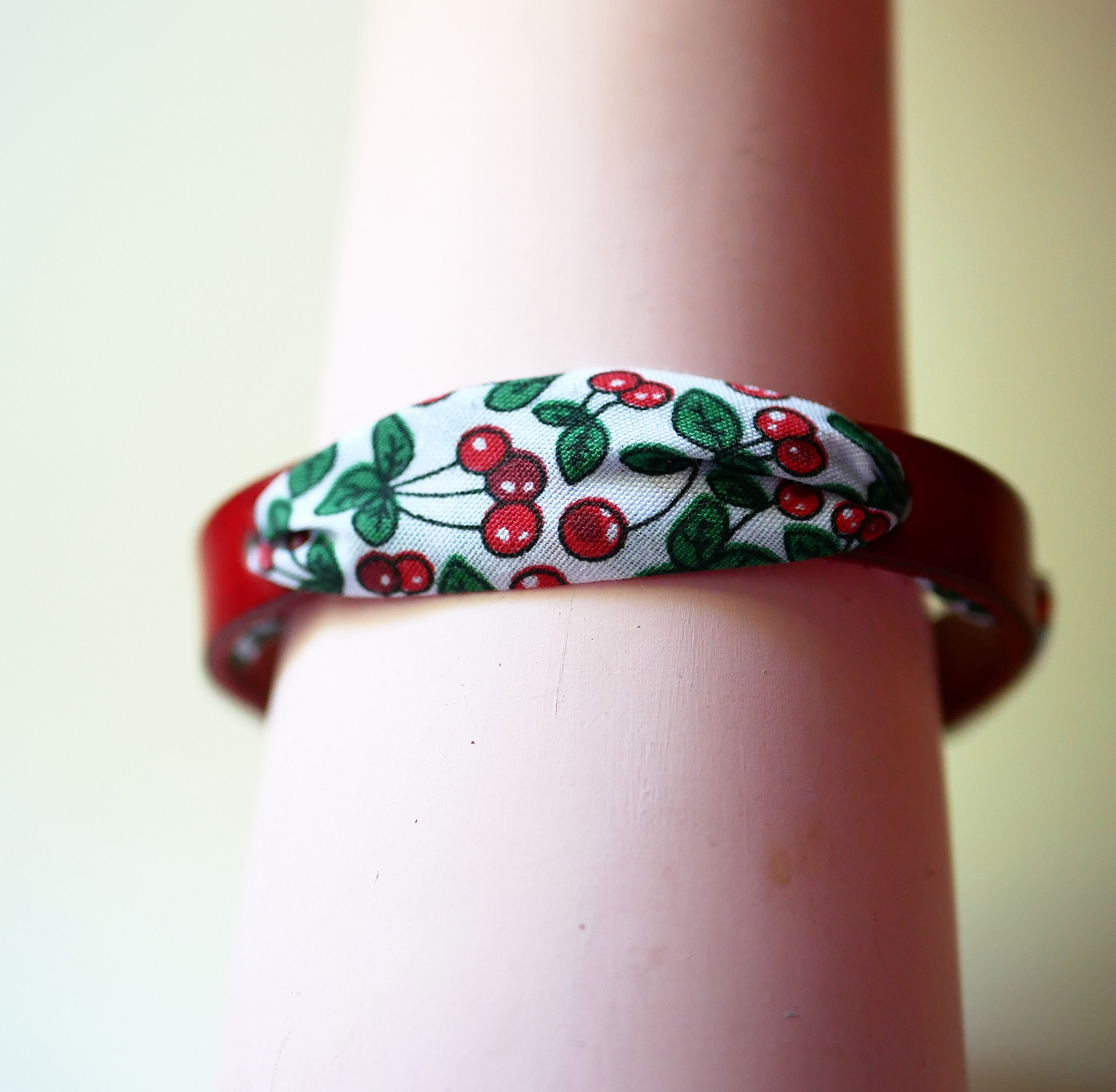 Pulsera Flor&acirc;me con cinta de cerezas sobre cuero rojo