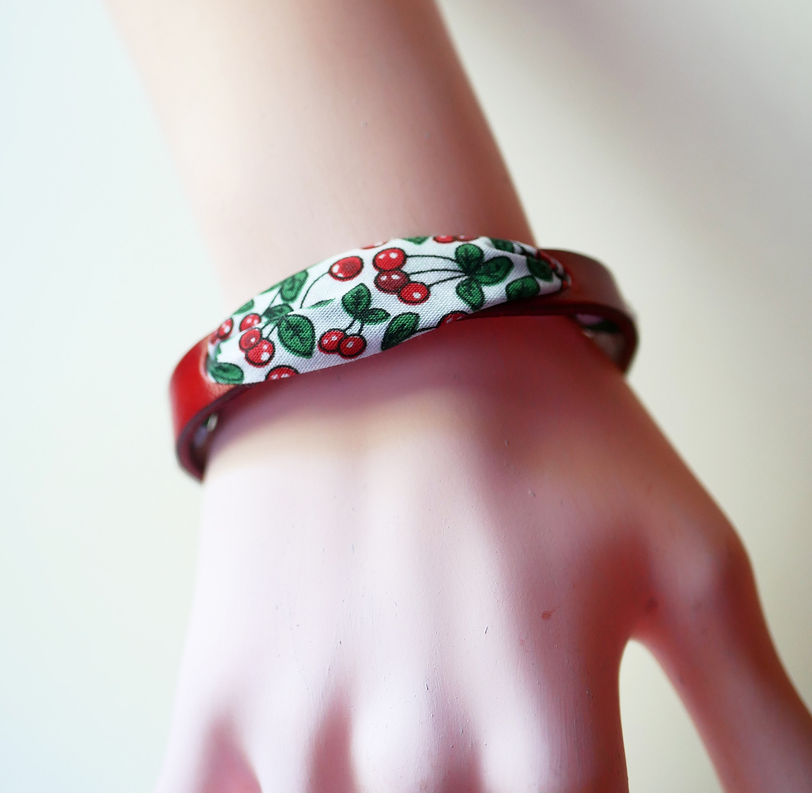 Pulsera Flor&acirc;me con cinta de cerezas sobre cuero rojo