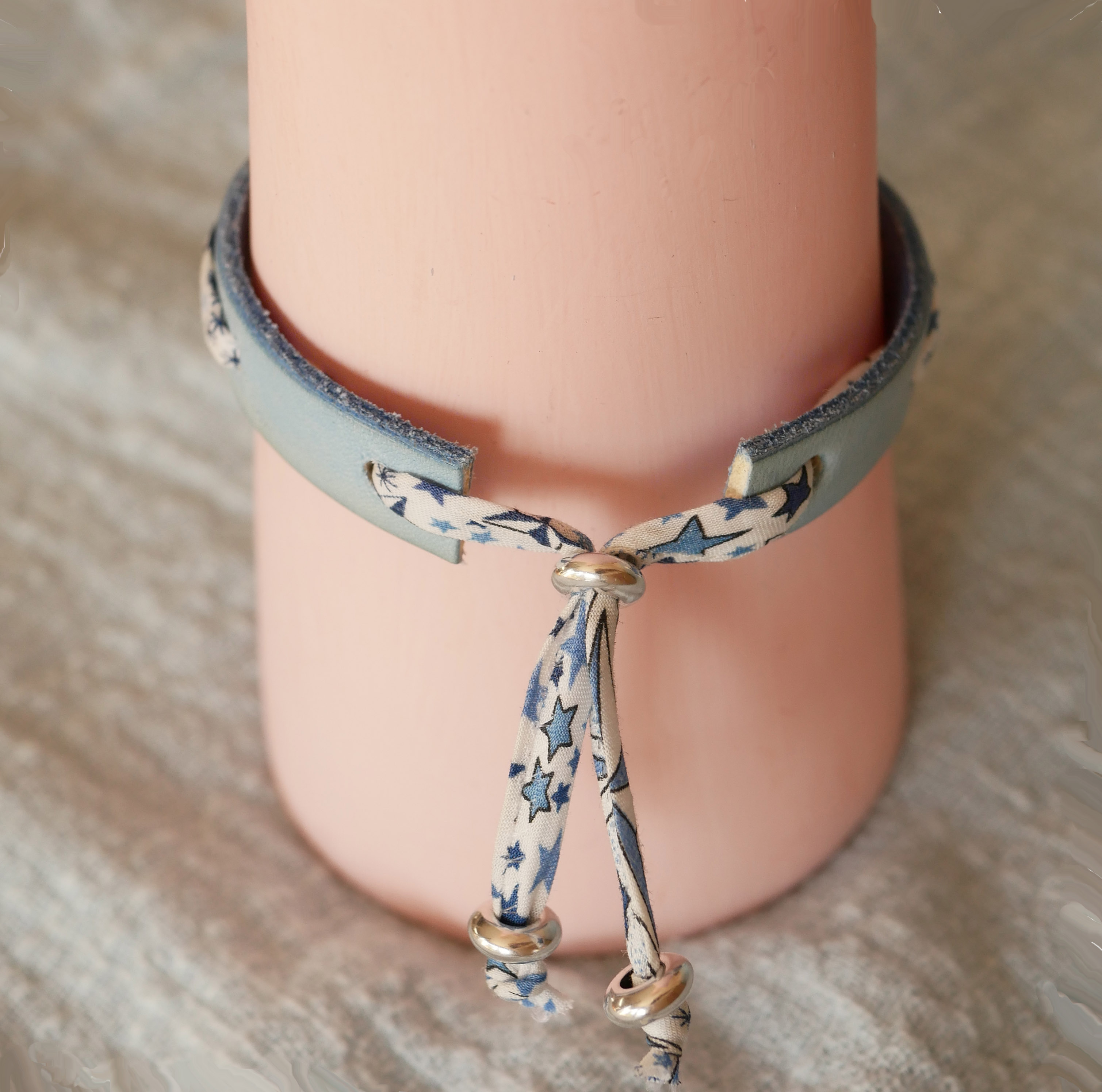 Pulsera Florâme con lazo liberty estrellas azules sobre cuero celeste