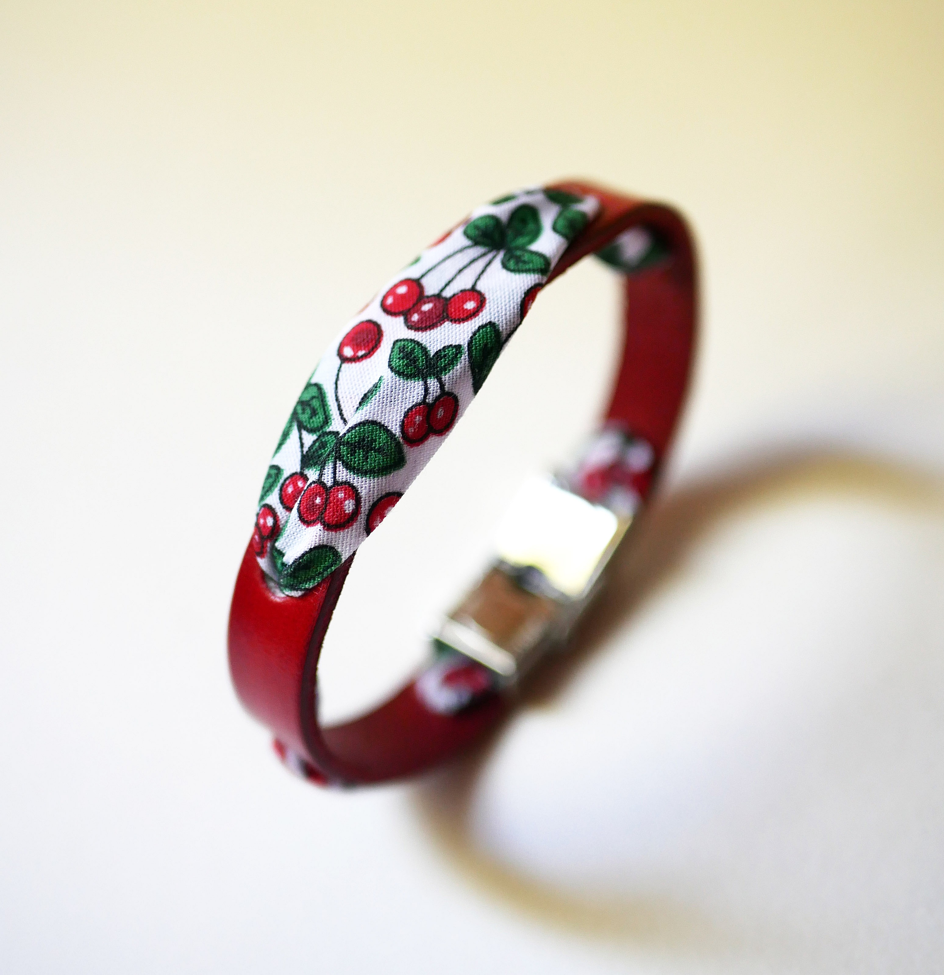 Pulsera Flor&acirc;me con cinta de cerezas sobre cuero rojo