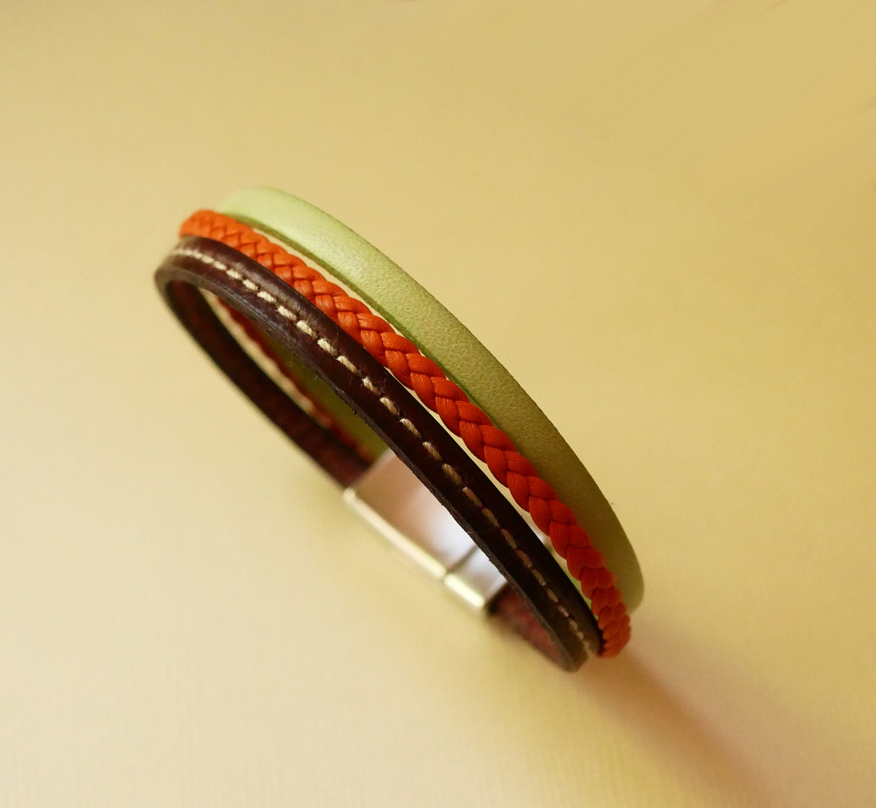 Pulsera brazalete multicuero con almendra, trenzado naranja y pespunte burdeos