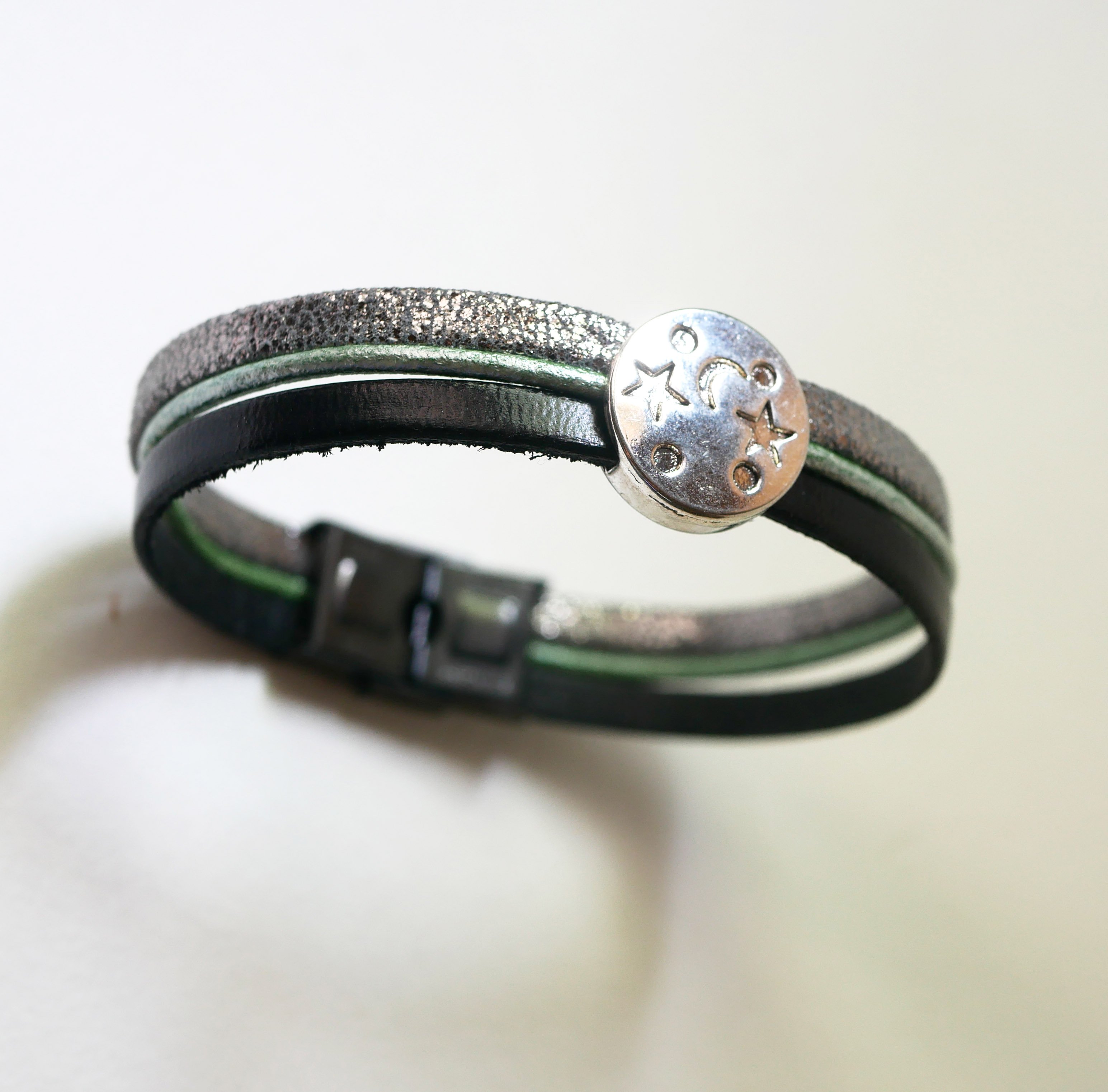 Pulsera multienlace de cuero con cabujones plateados, verdes y negros en forma de estrella lunar