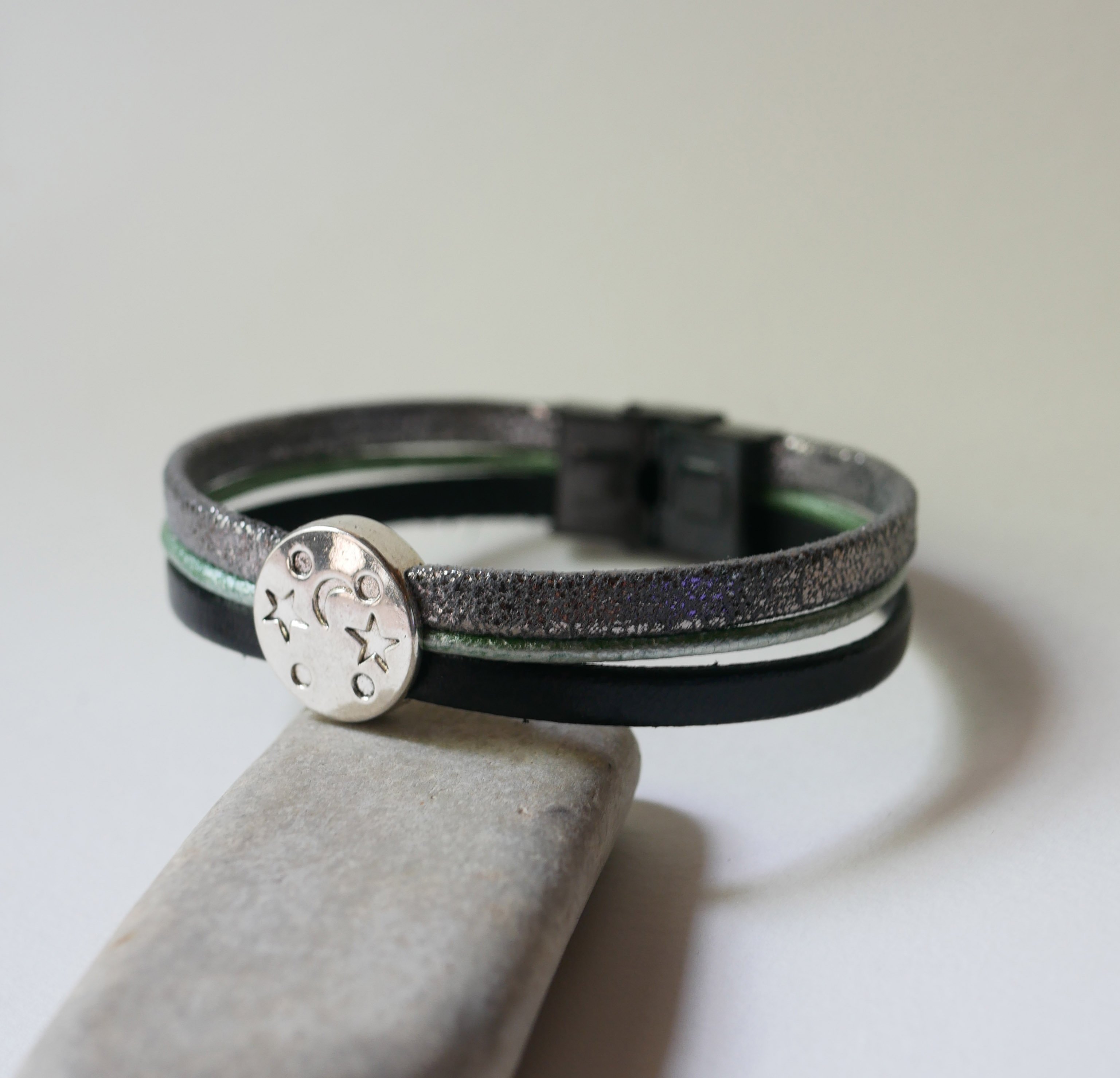 Pulsera multienlace de cuero con cabujones plateados, verdes y negros en forma de estrella lunar