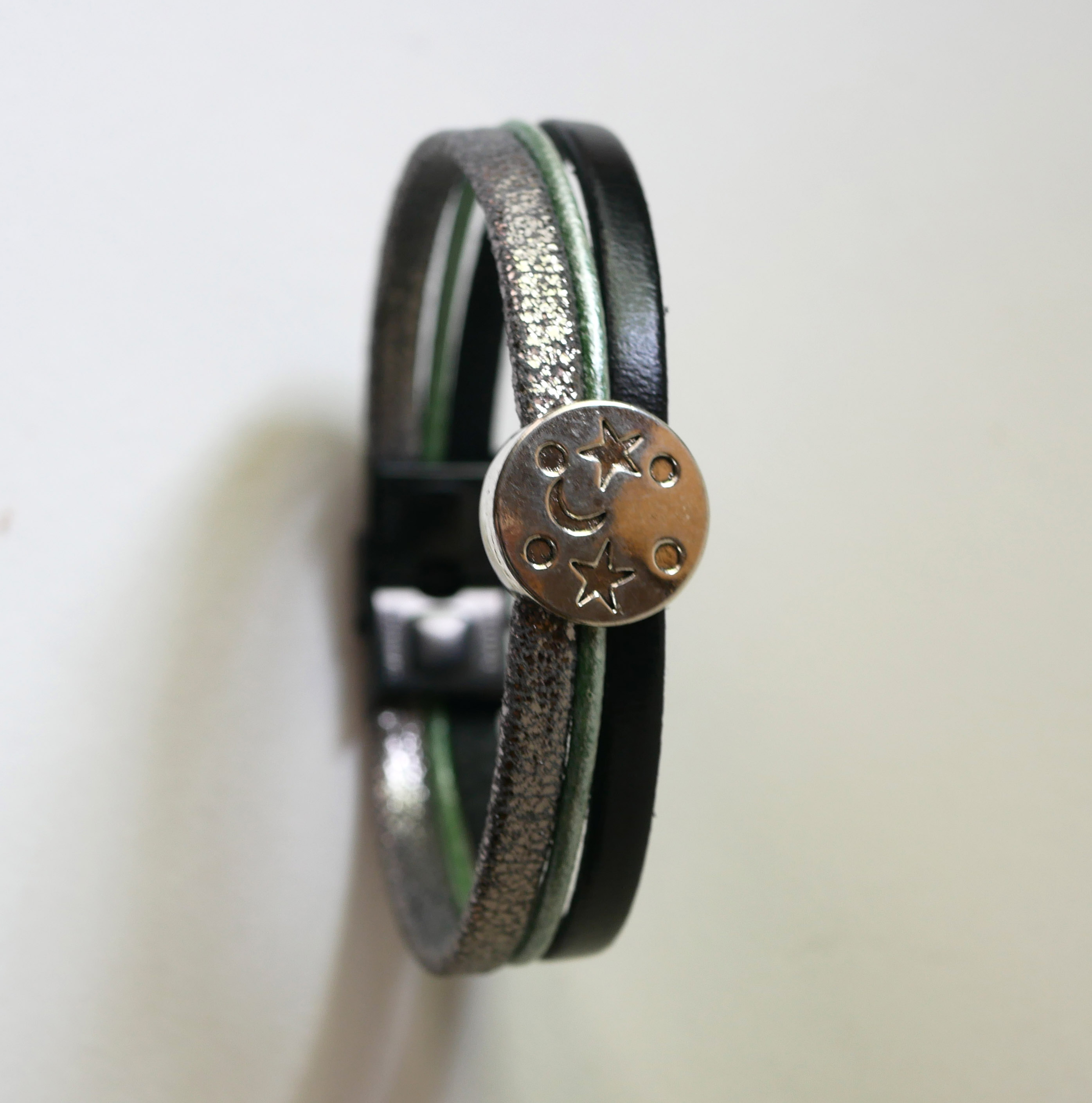 Pulsera multienlace de cuero con cabujones plateados, verdes y negros en forma de estrella lunar