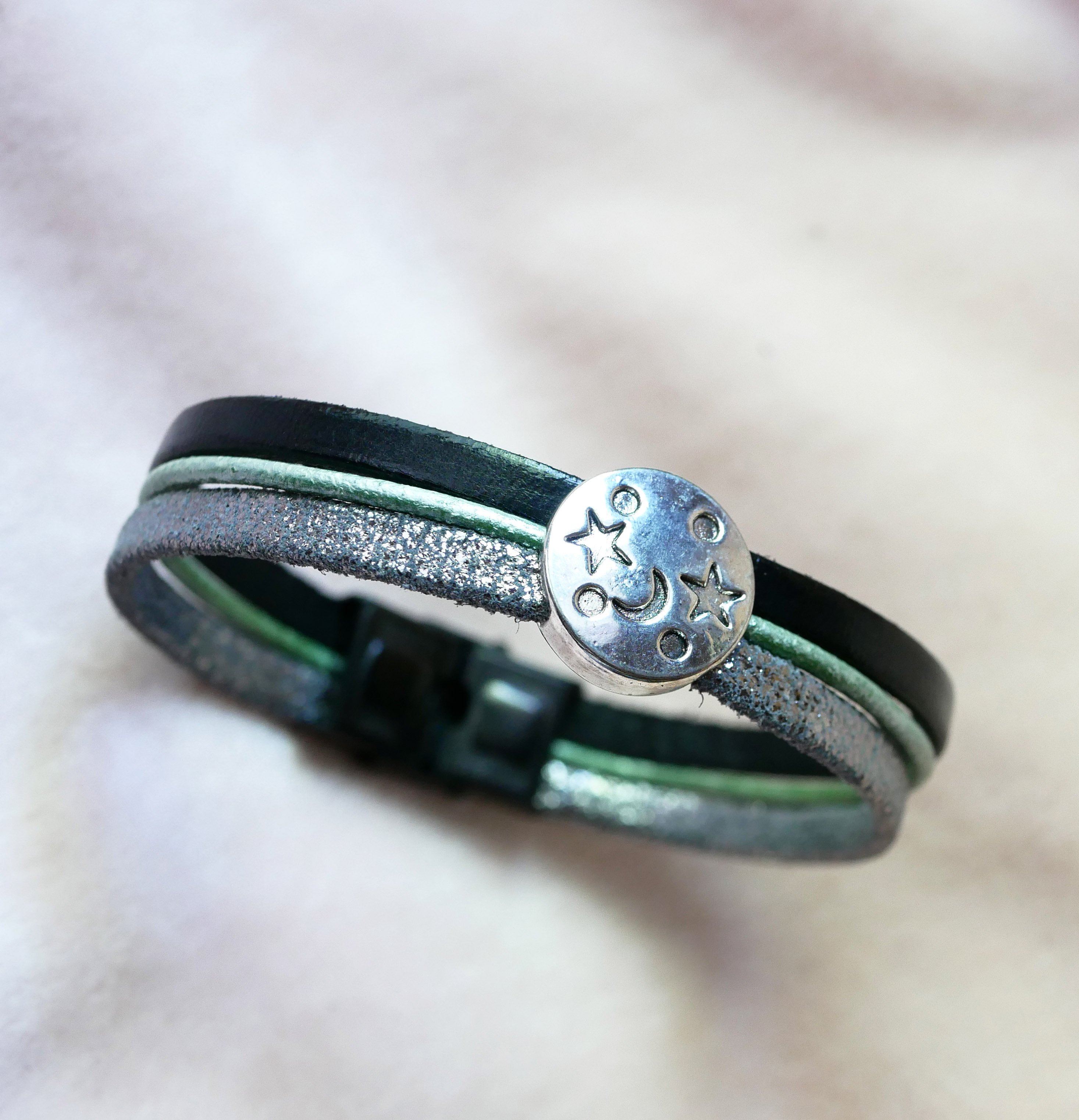 Pulsera multienlace de cuero con cabujones plateados, verdes y negros en forma de estrella lunar