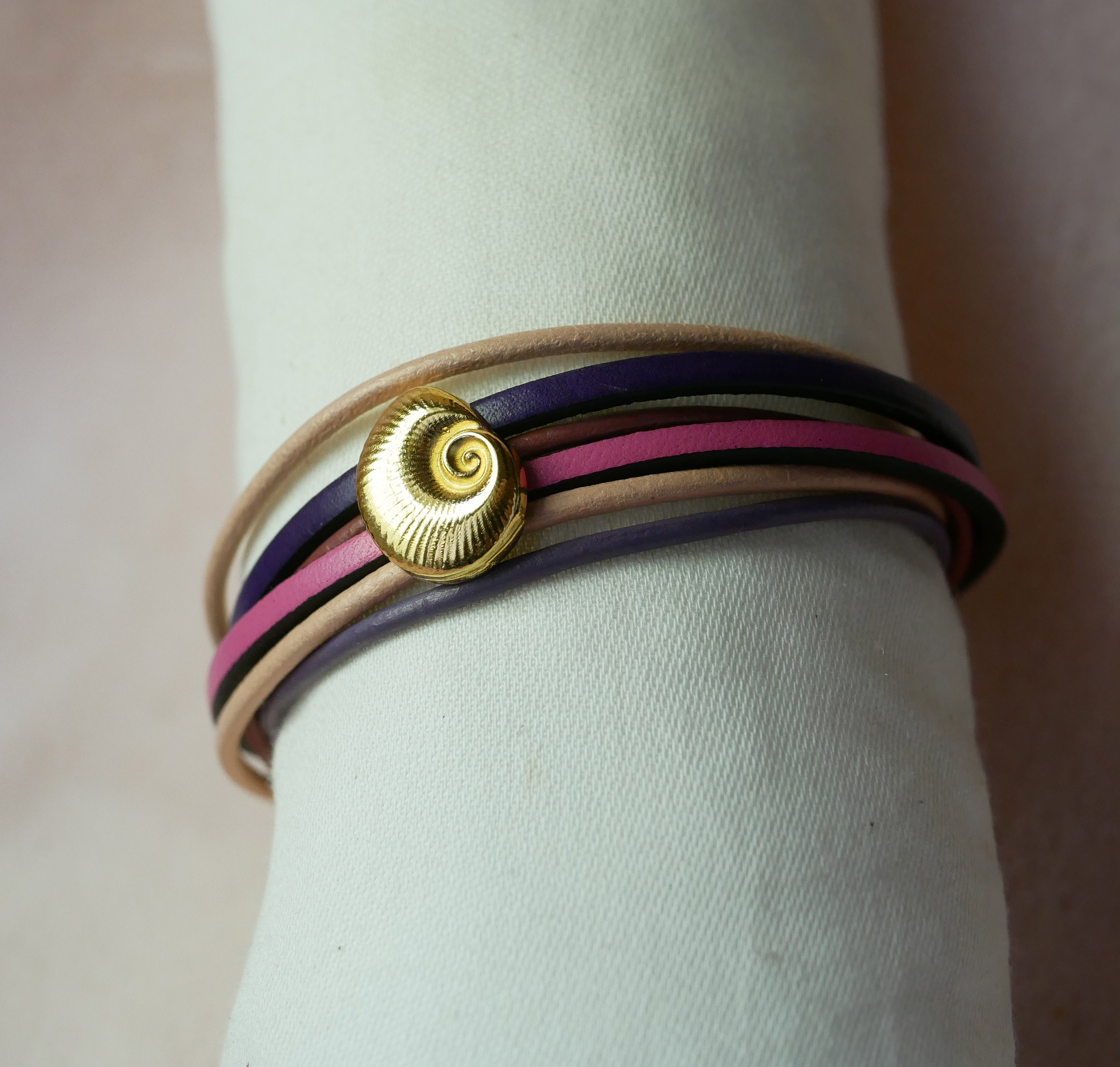 Pulsera de eslabones múltiples en pieles melocotón y malva con adorno de concha dorada