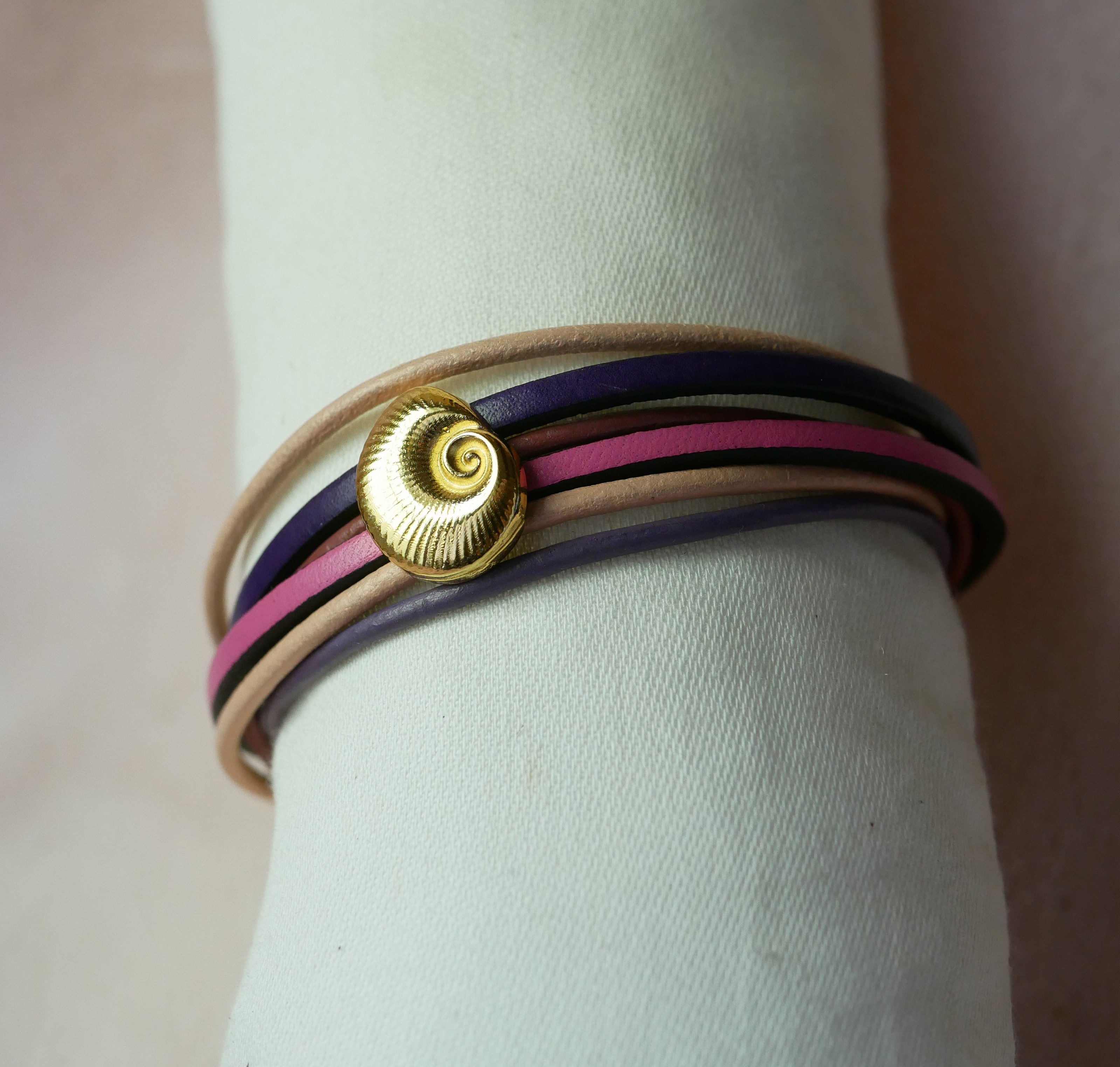 Pulsera de eslabones m&uacute;ltiples en pieles melocot&oacute;n y malva con adorno de concha dorada