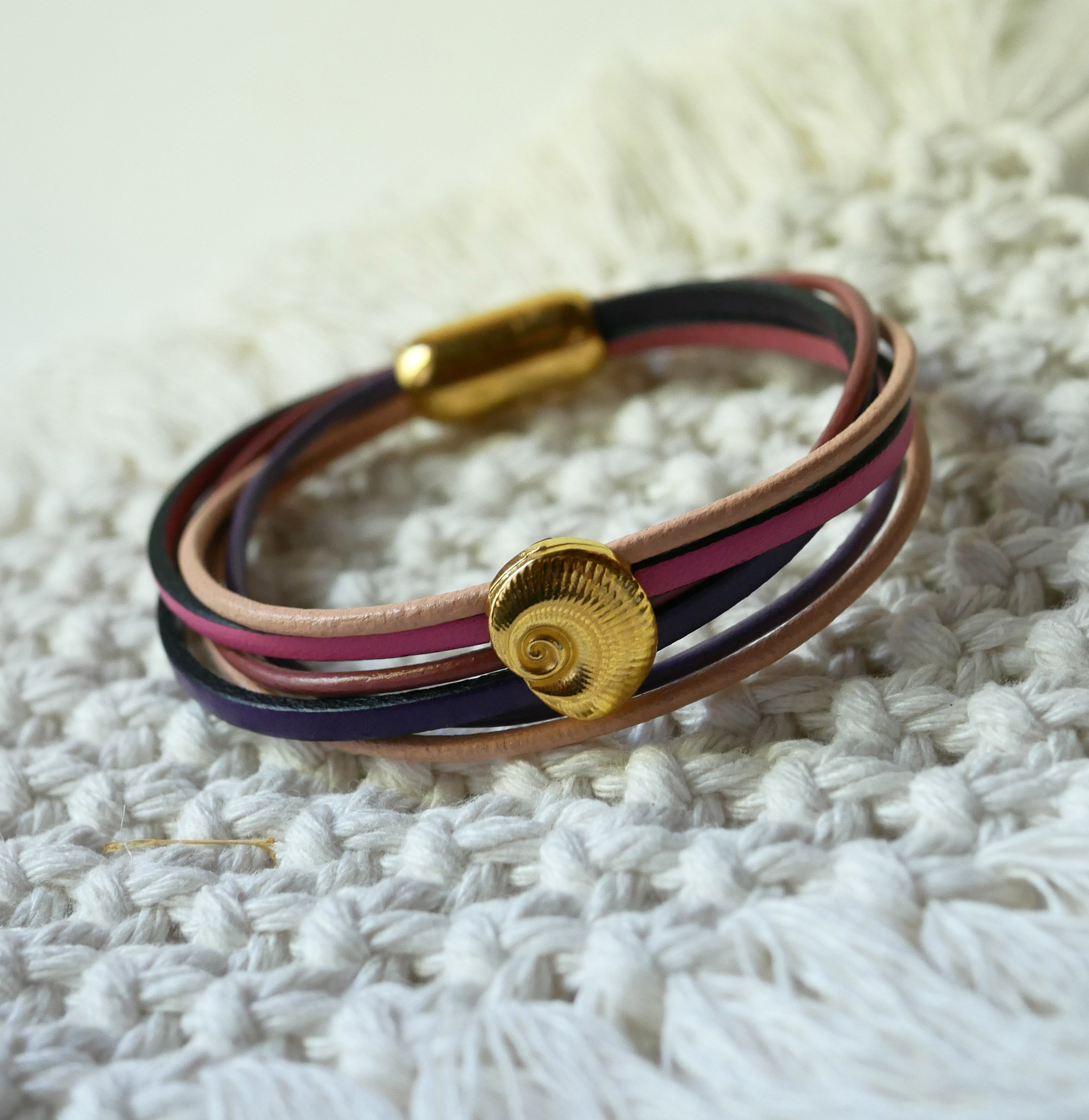 Pulsera de eslabones múltiples en pieles melocotón y malva con adorno de concha dorada