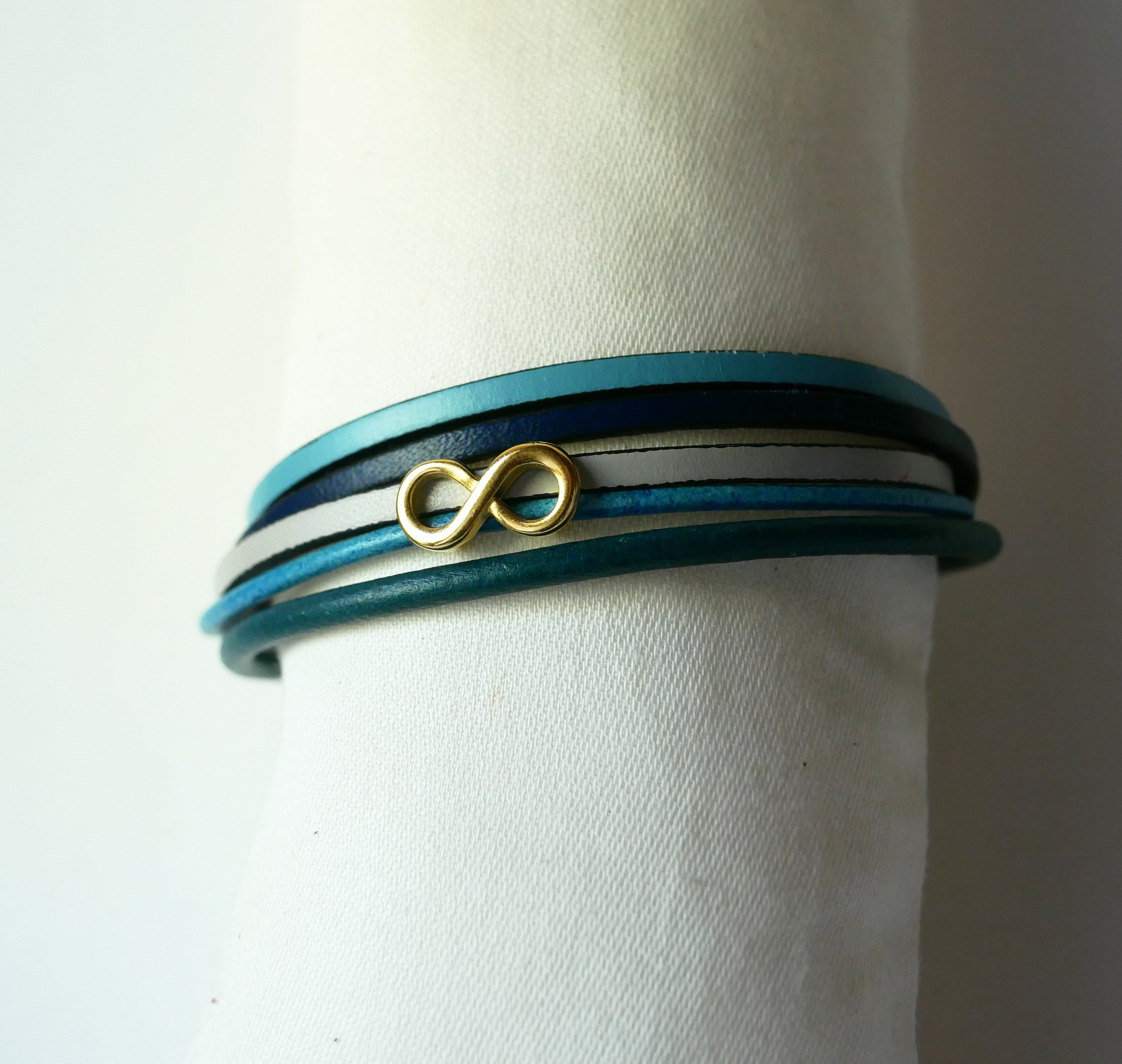 Pulsera de eslabones múltiples de piel azul con motivo infinito dorado