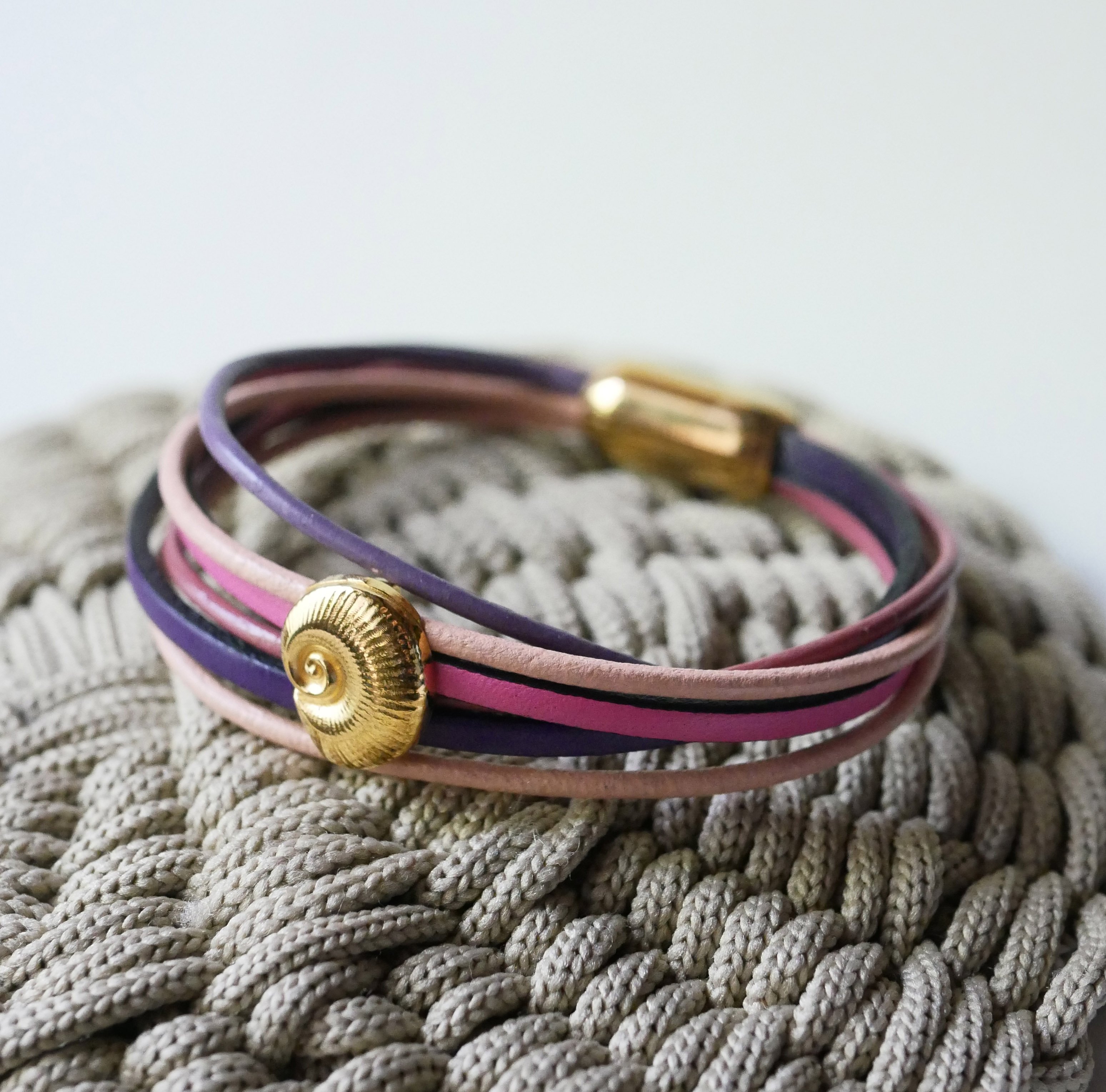 Pulsera de eslabones múltiples en pieles melocotón y malva con adorno de concha dorada