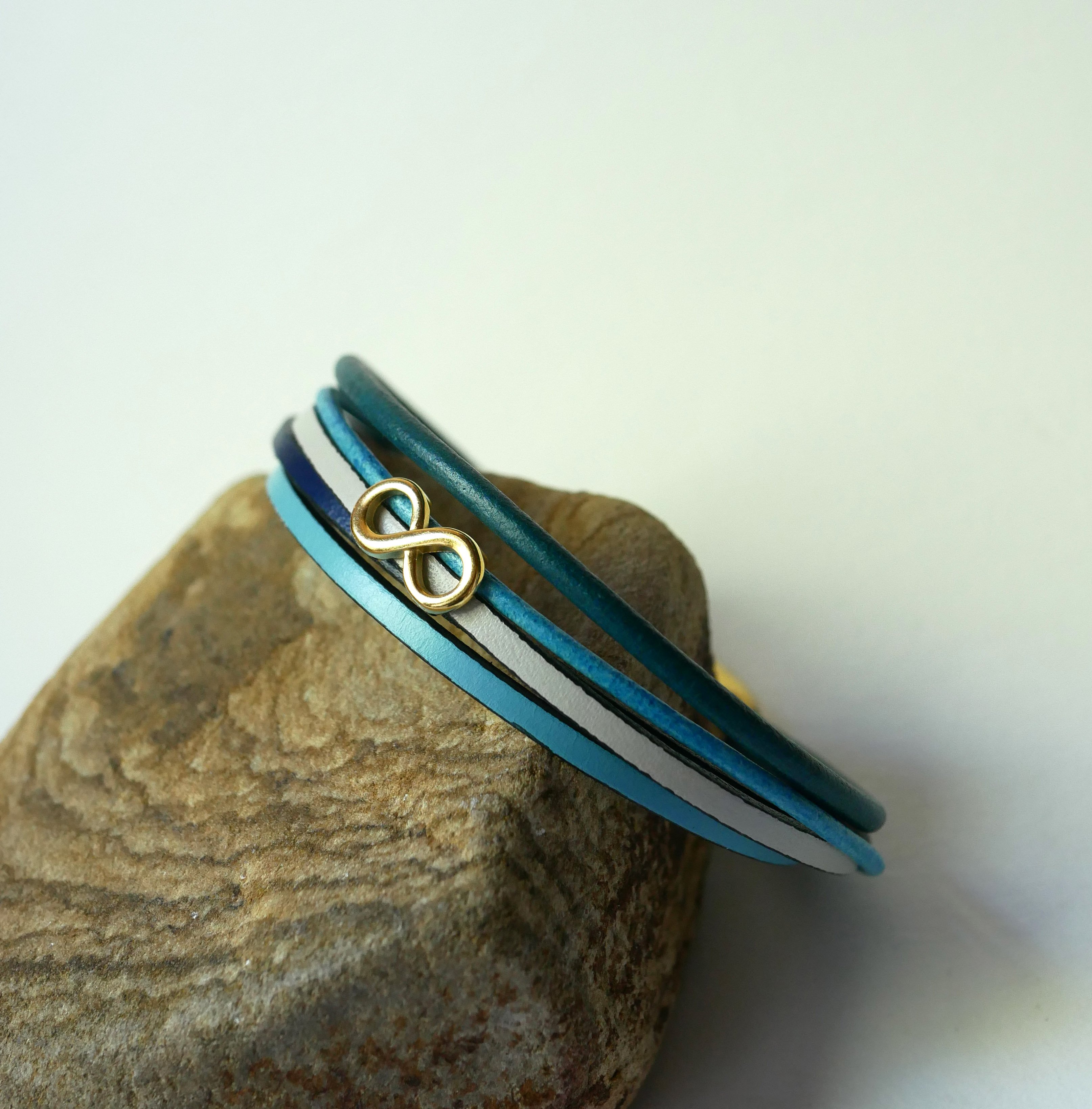 Pulsera de eslabones múltiples de piel azul con motivo infinito dorado