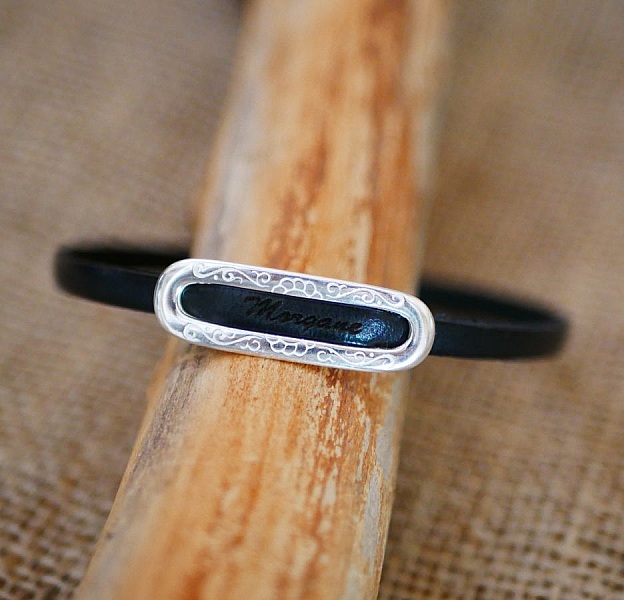 Bracelet en cuir noir avec plaque gravée personnalisée.