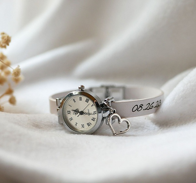 Montre bracelet personnalisée avec date gravée et breloque cœur.