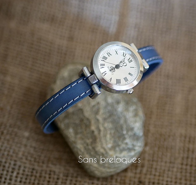 Montre femme bracelet cuir bleu avec surpiqûres blanches.