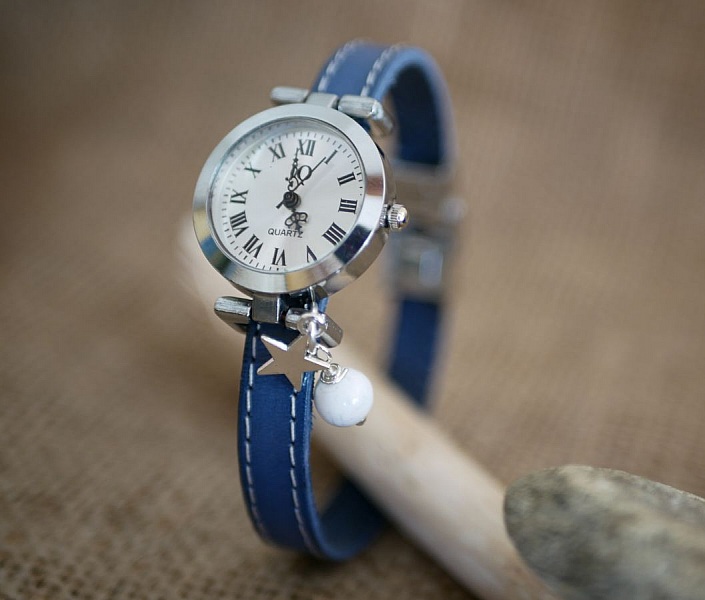 Montre bracelet cuir bleu avec breloque étoile et perle.