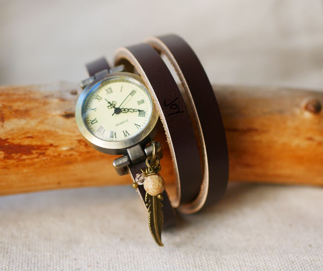 Reloj pulsera de piel con colgantes de plumas y perlas