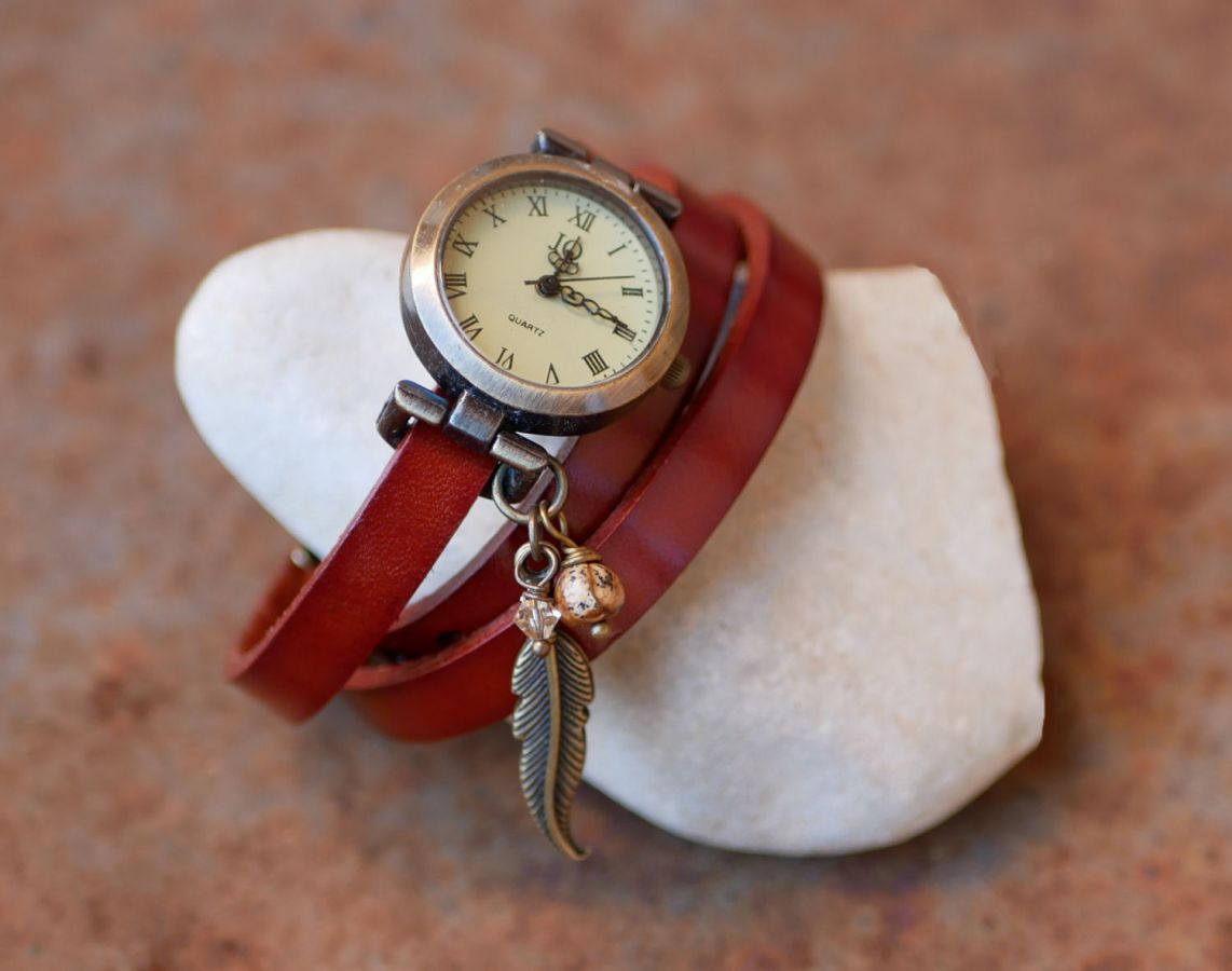 Reloj pulsera de piel con colgantes de plumas y perlas