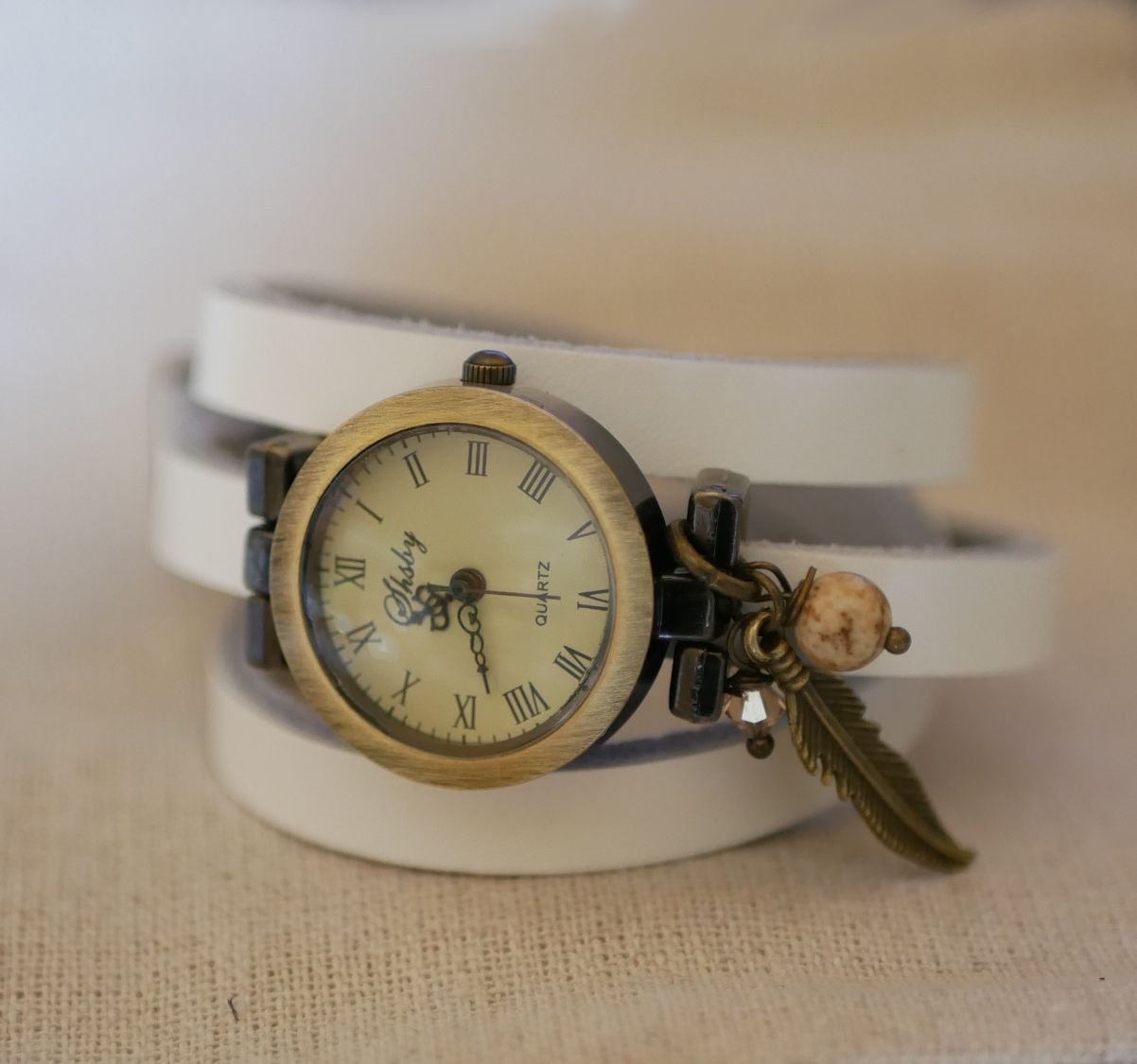 Reloj pulsera de piel con colgantes de plumas y perlas