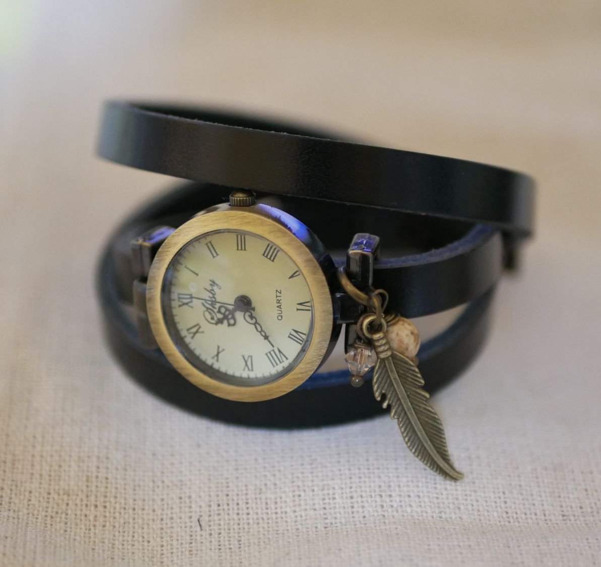 Reloj pulsera de piel con colgantes de plumas y perlas