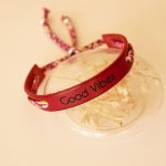 Florâme Pulsera Good vibes grabada con lazo liberty morado sobre piel roja