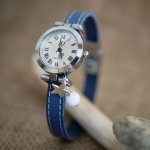 Reloj con correa de piel azul y pespuntes blancos